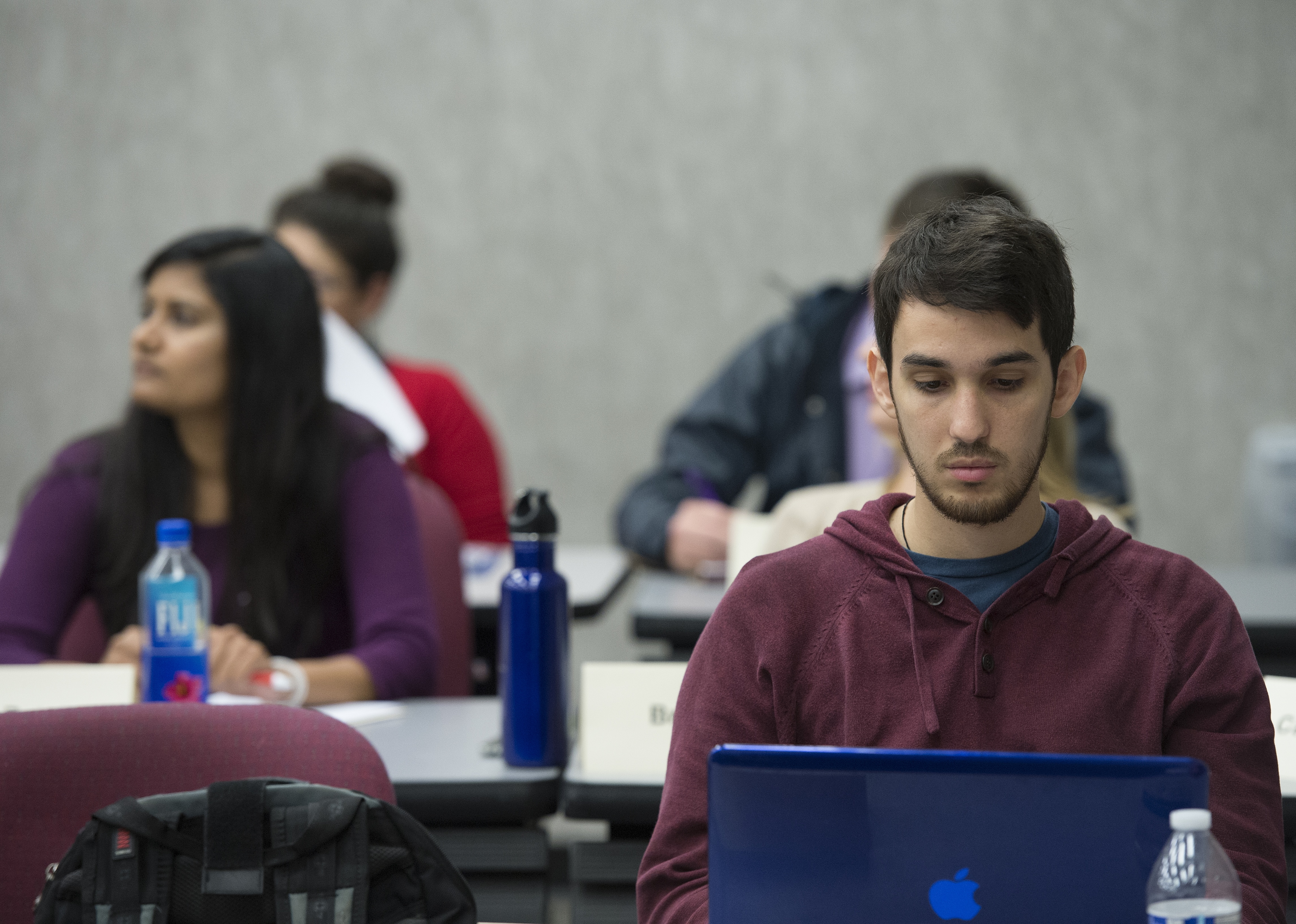 A student typing notes on their laptop during their lecture